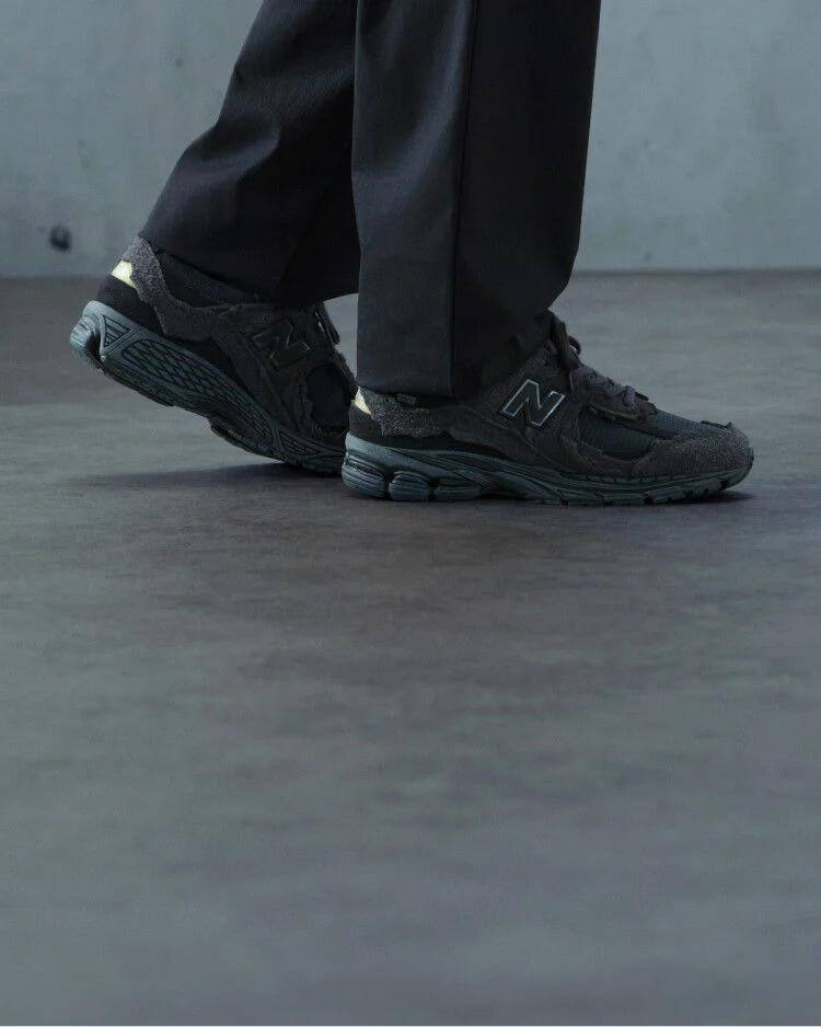 A pair of New Balance sneakers on concrete floor.